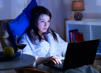 Attractive girl is spending time in front of her laptop