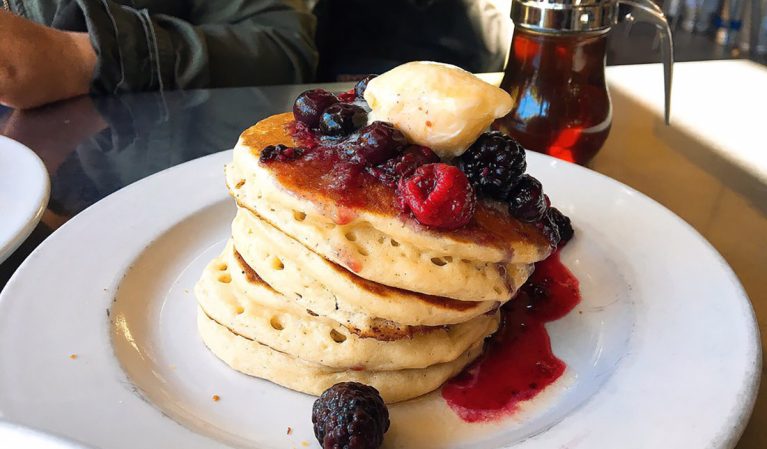 stack of pancakes with berries and lemon butter
