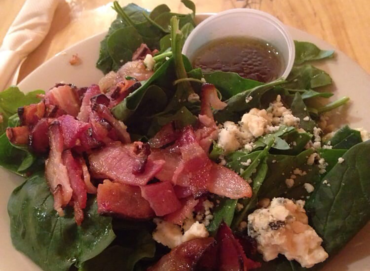 spinach salad topped with bacon and cheese