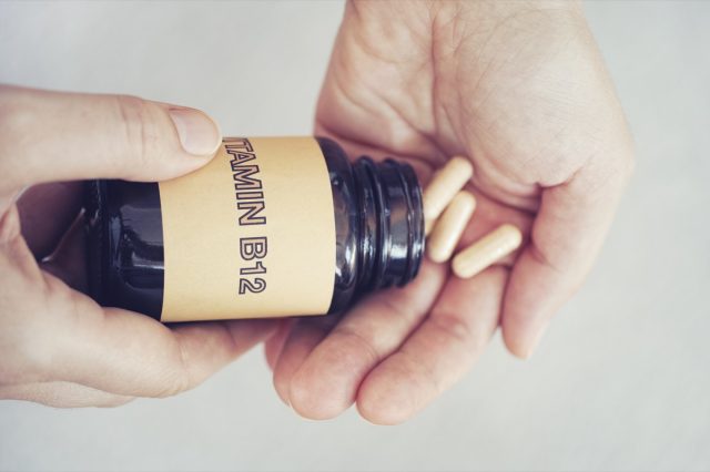 A person takes vitamin B12 tablets by the bottle.