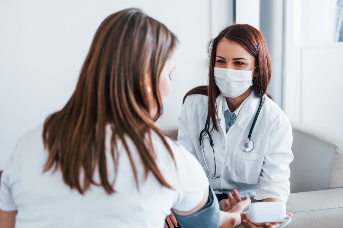 A woman has her blood pressure checked by a female doctor.