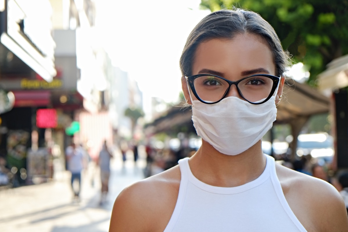 Woman wearing face mask on the busy street.