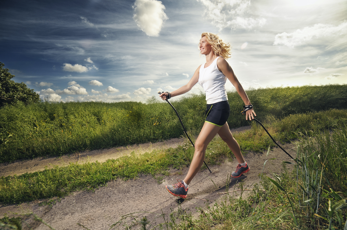 woman nordic walking outdoors with proper form