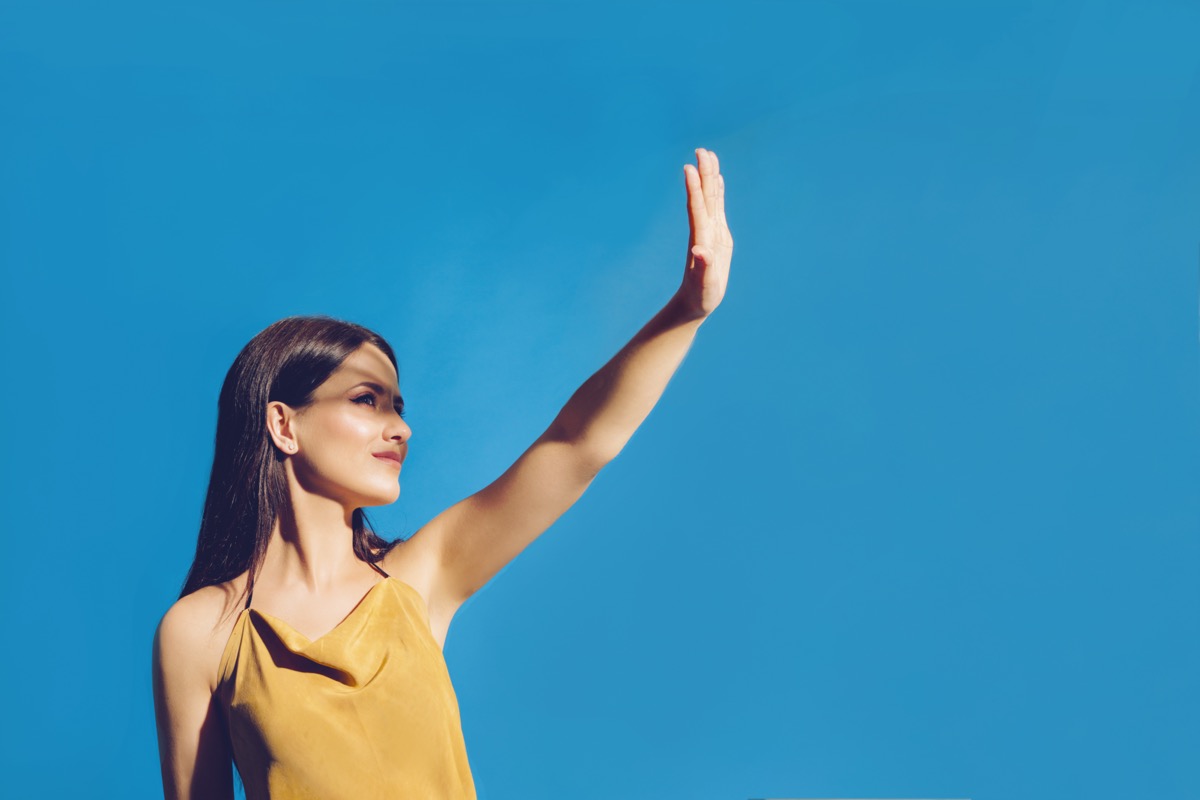 Woman covering her face to block the sun light.