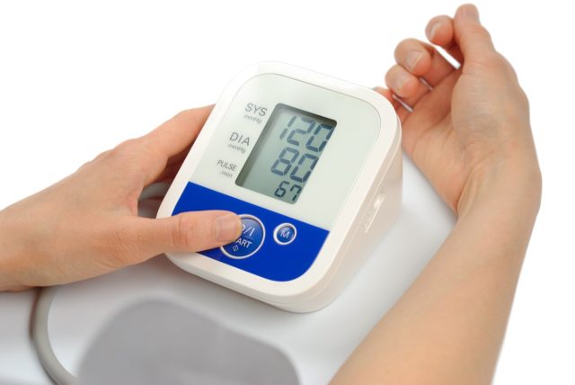 Woman measuring blood pressure 120/80.