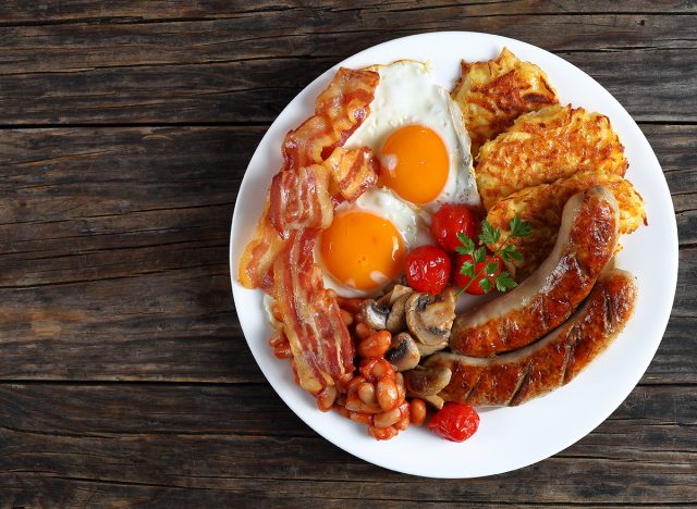 English breakfast with bacon, sausage, fried egg and beans