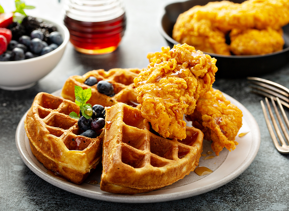 chicken and waffles with bowl of fresh blueberries
