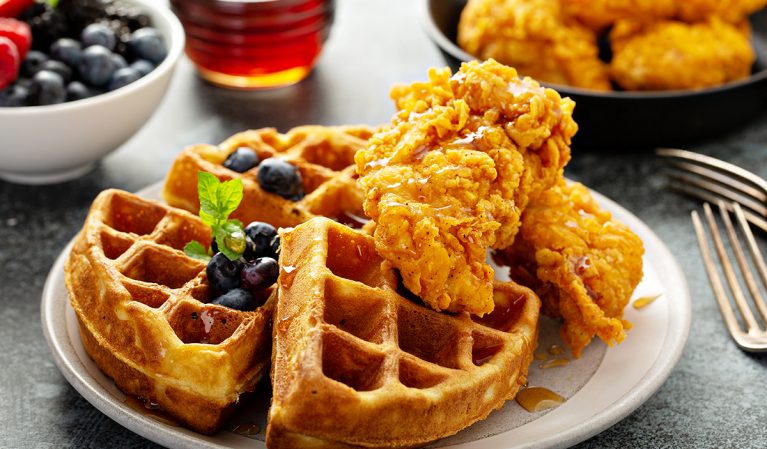 chicken and waffles with bowl of fresh blueberries