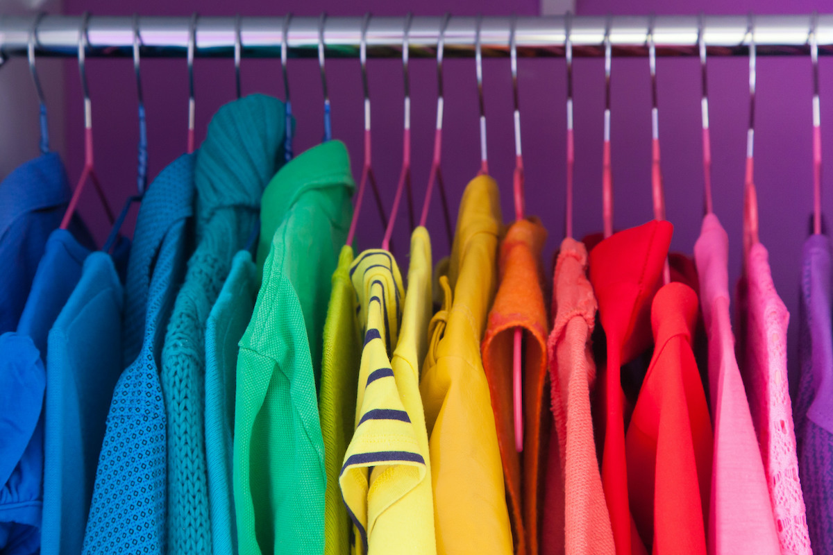 Colored clothing of all colors of the rainbow / spectrum hanging in the wardrobe.
