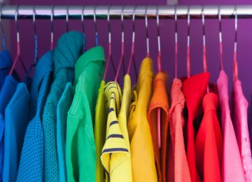Colored clothing of all colors of the rainbow / spectrum hanging in the wardrobe.