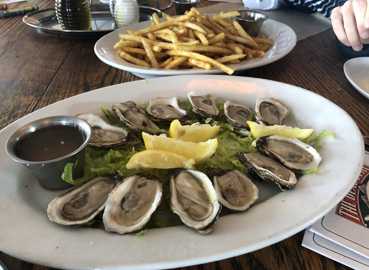 plate of raw oysters with lemon wedges