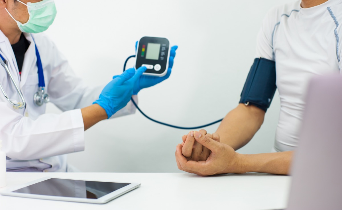 The doctor uses a sphygmomanometer to check a patient's blood pressure.