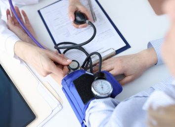 doctor measuring a patient's blood pressure with blood pressure cuff
