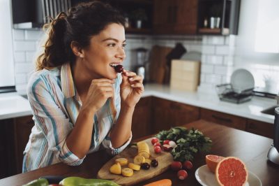 A young smiling woman having healthy breakfast in the morning