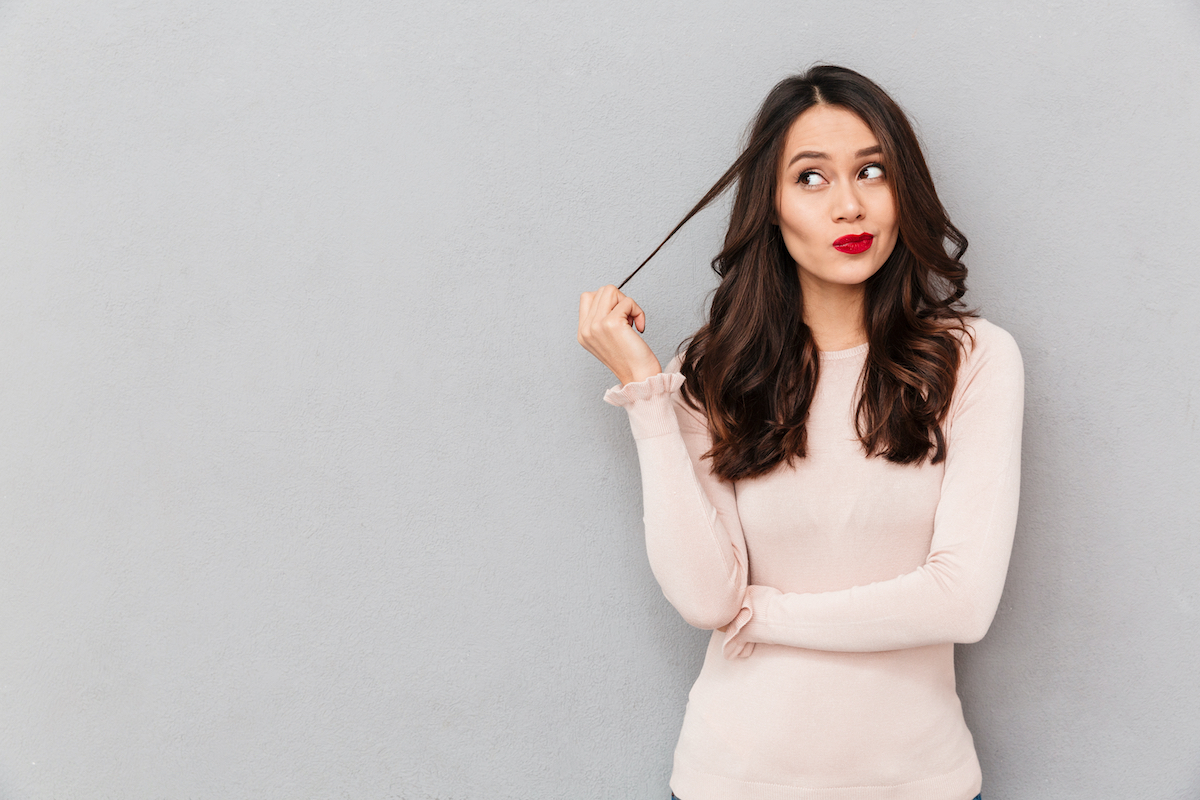 judgmental woman who is a narcissist standing twirling hair