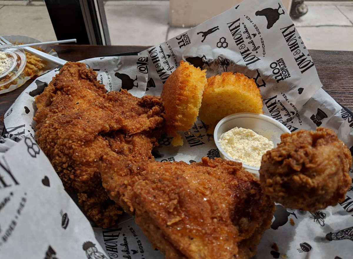 basket of fried chicken with two biscuits and honey butter