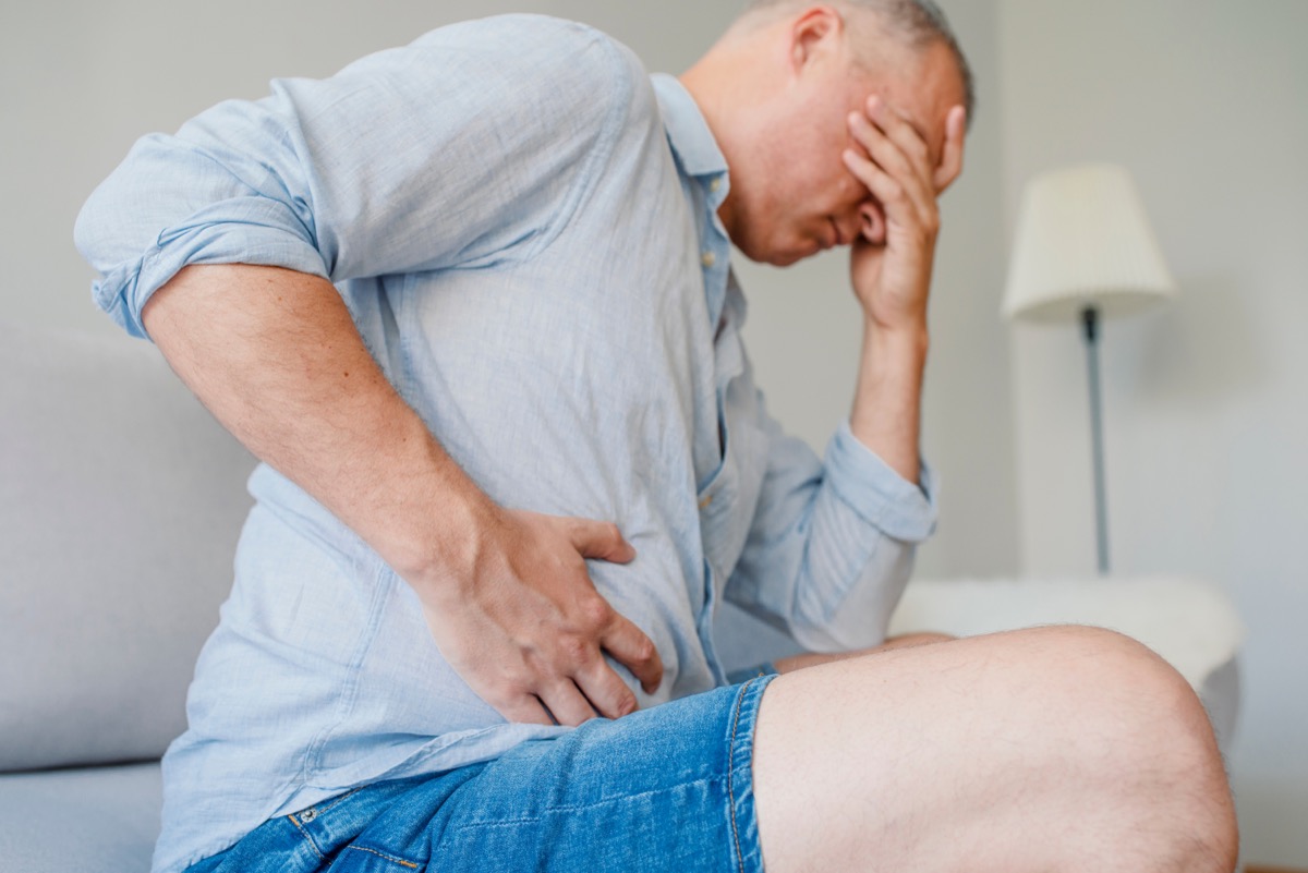 middle-aged man doubled over in liver pain