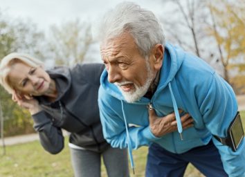 Senior man suffering heart attack while jogging with wife.