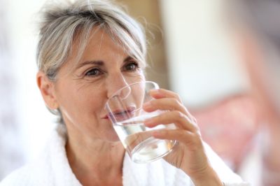 Senior woman drinking water in the morning