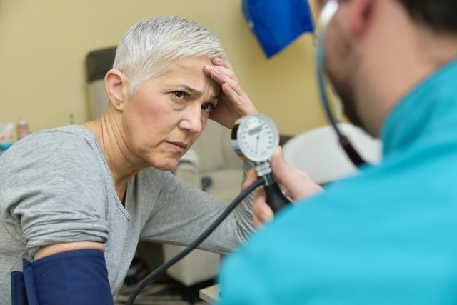 Senior lady receiving bad news about her blood pressure from her doctor