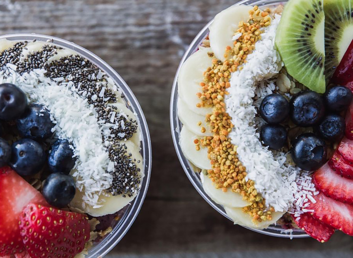 two smoothie bowls with fresh fruit and coconut