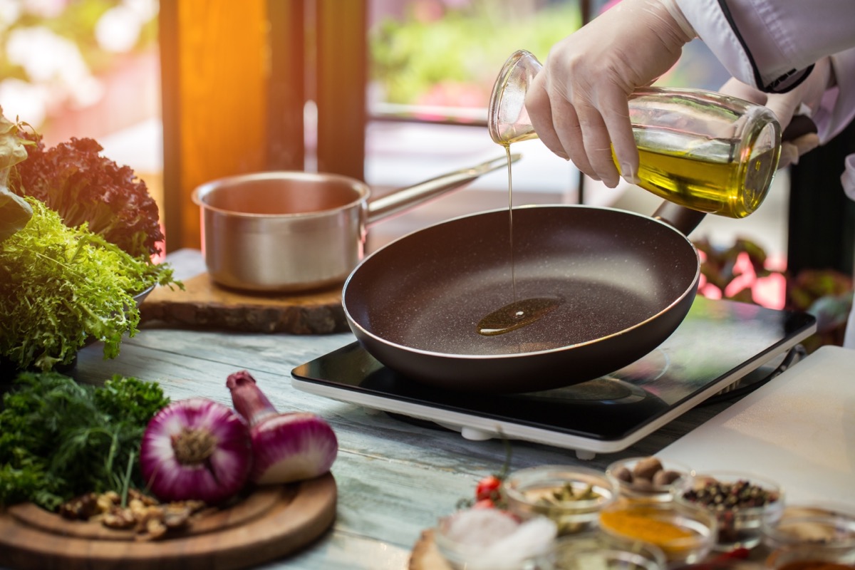 person pouring oil into nonstick pan