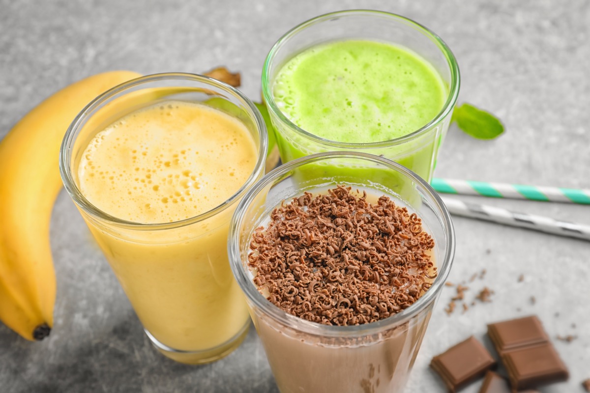 Glasses with different protein shakes on table