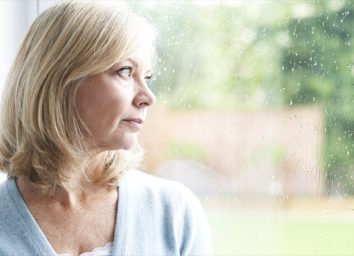 Sad mature woman looking out of window.