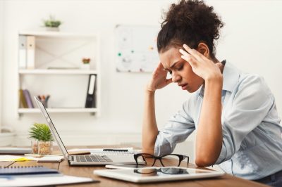 stressed out young woman sitting at desk