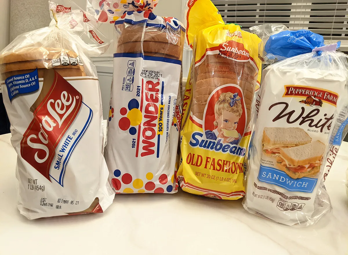 four packaged white bread loaves