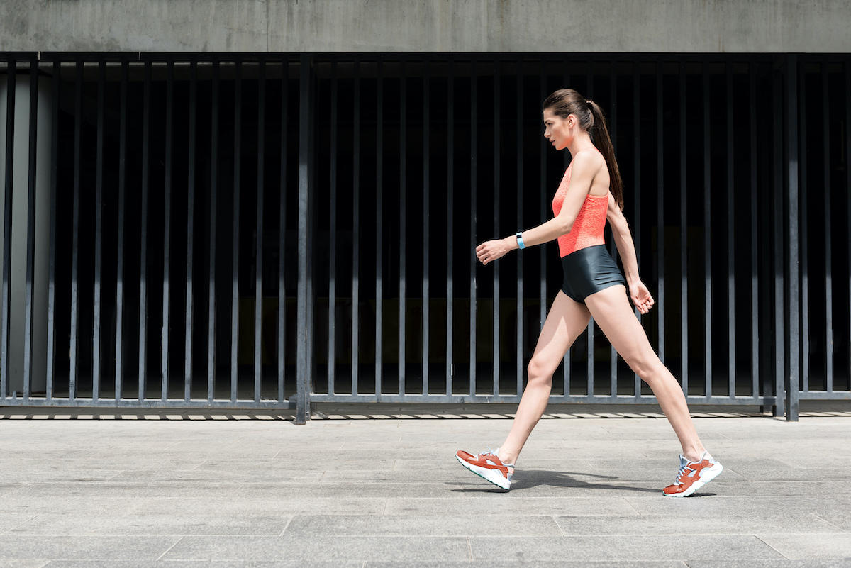 Slim sporty young girl walking on street