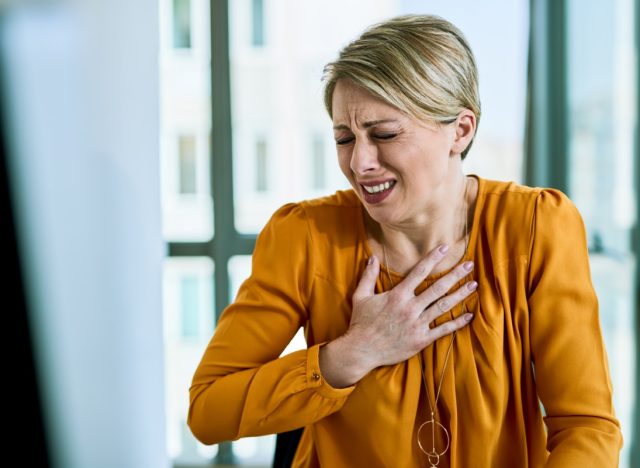 Businesswoman feeling chest pain while working in the office.
