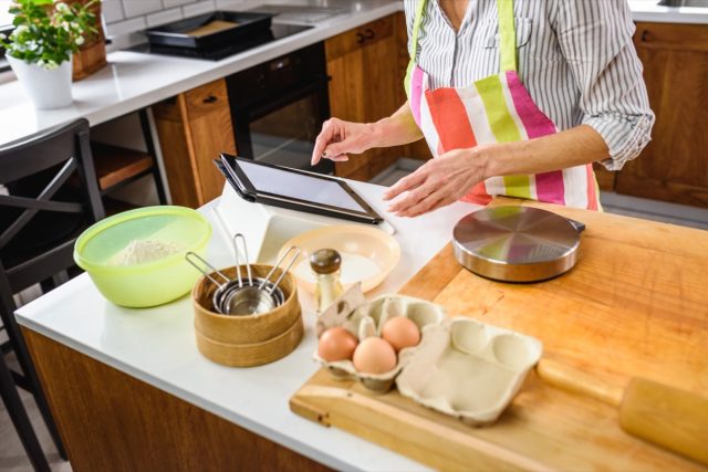 Senior aged woman baking in home kitchen.