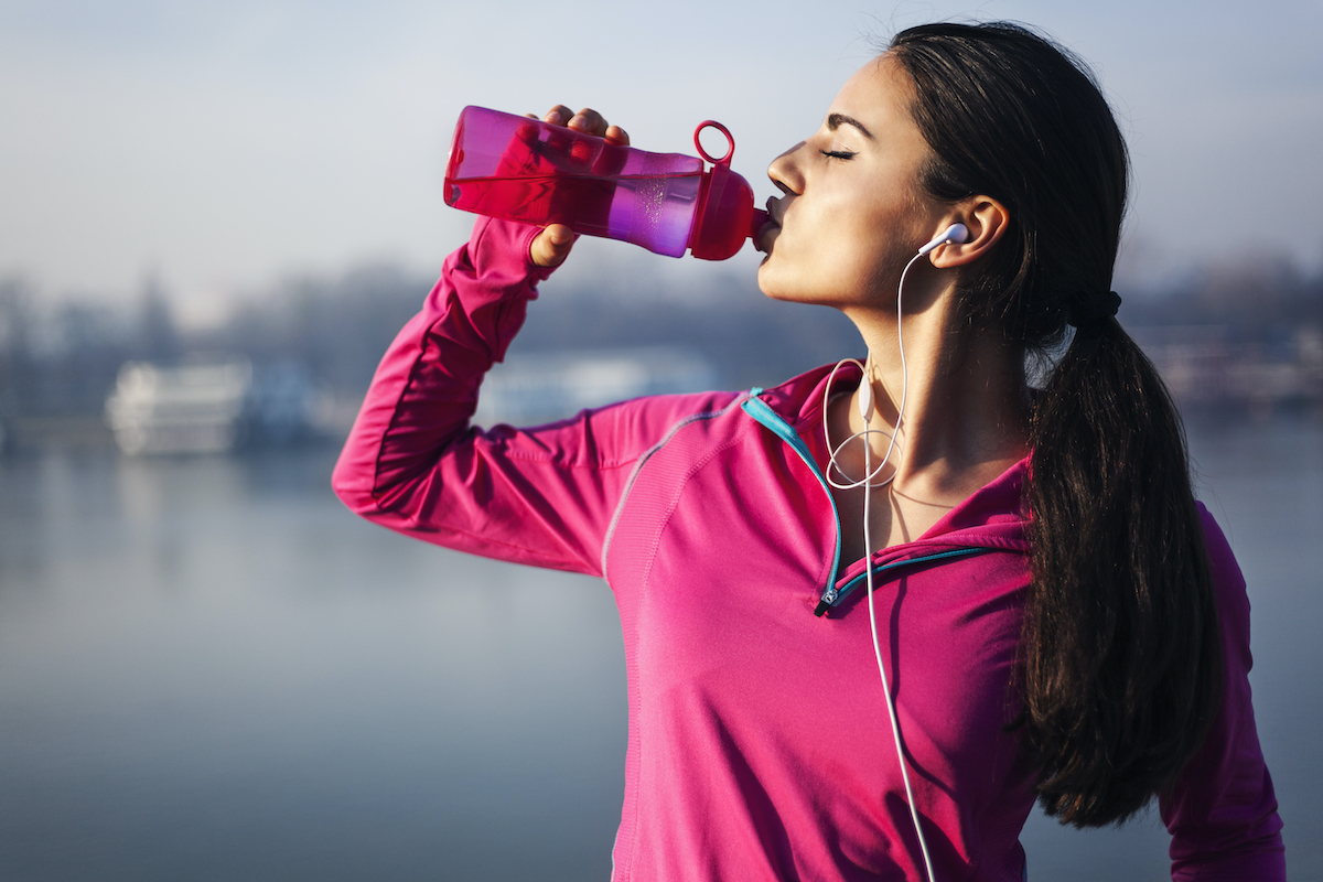 woman drinking water after a workout