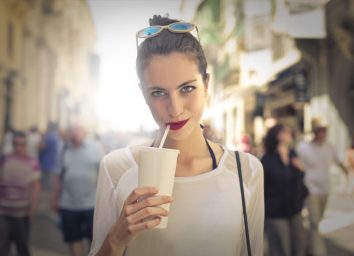 woman drinking out of white cup with straw
