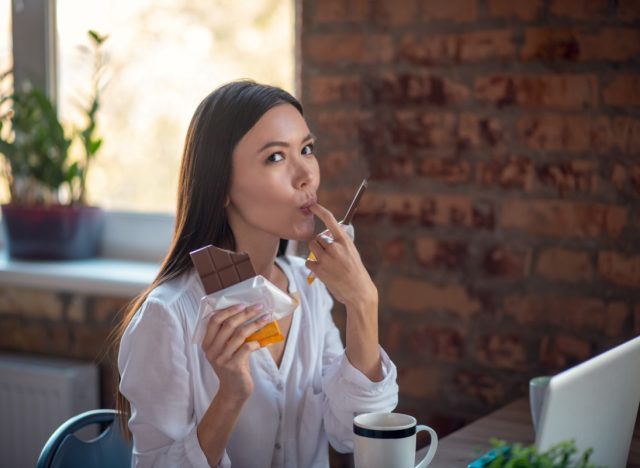 happy woman holding a bar of chocolate