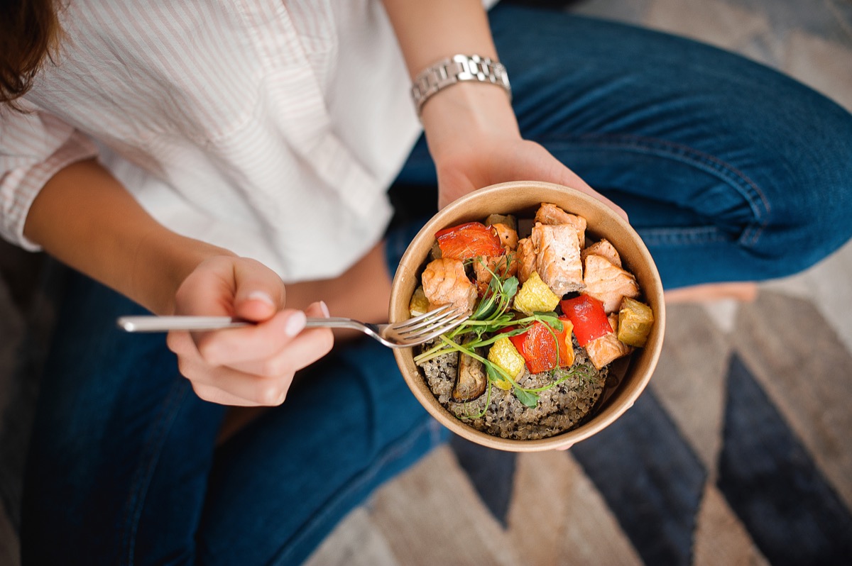 woman eating salmon and quinoa