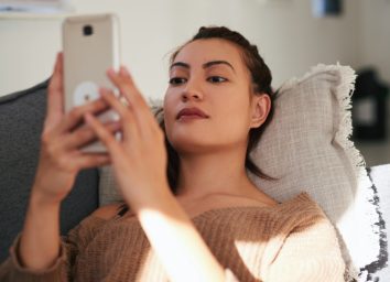 woman using a smartphone on the sofa at home