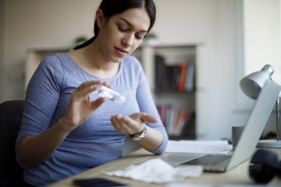 Woman applying an antibacterial antiseptic hand gel for hands disinfection