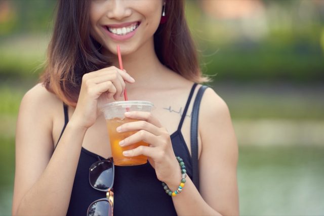young woman drinking iced tea
