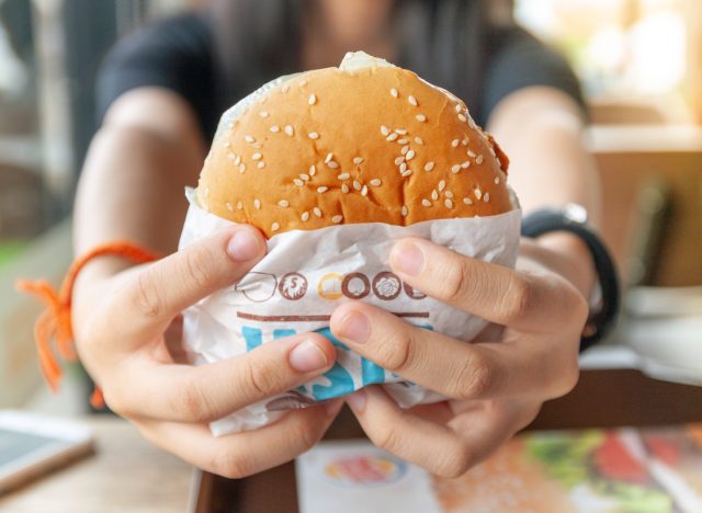 person holding burger king burger