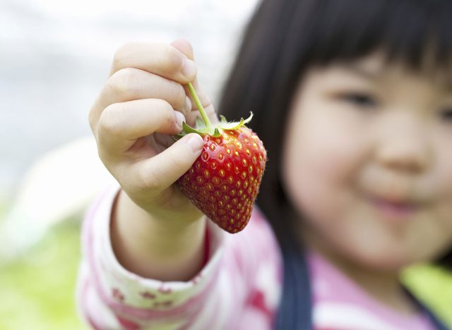 child holding strawberry