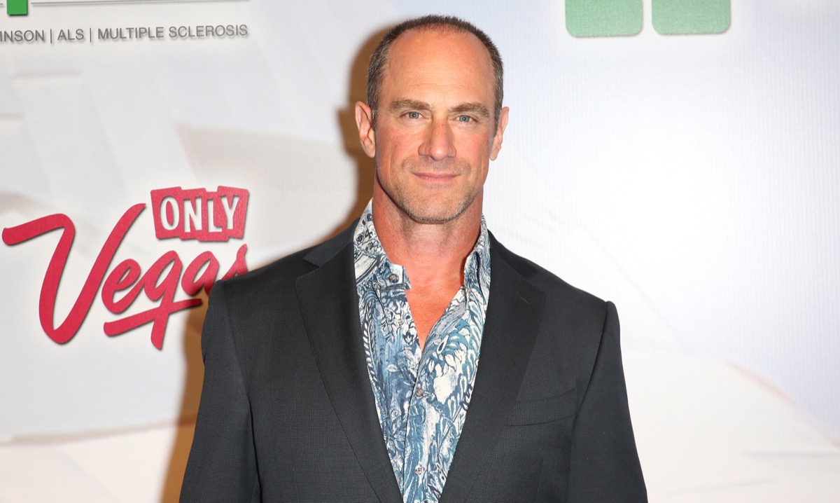 christopher meloni smiling on red carpet in blue shirt and gray blazer