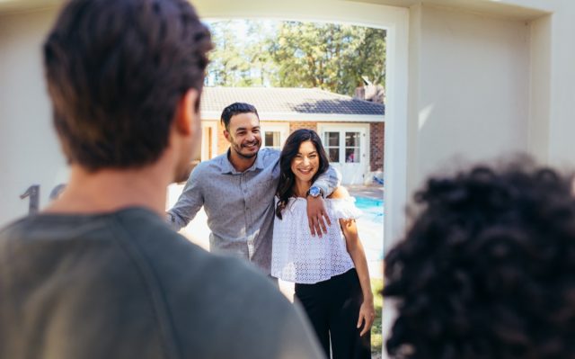 Couple inviting friend at their new house