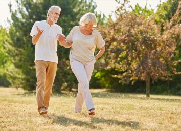 Mature couple holding hands on a walk in the park in summer