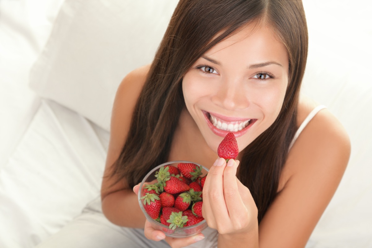 Woman eating strawberries.