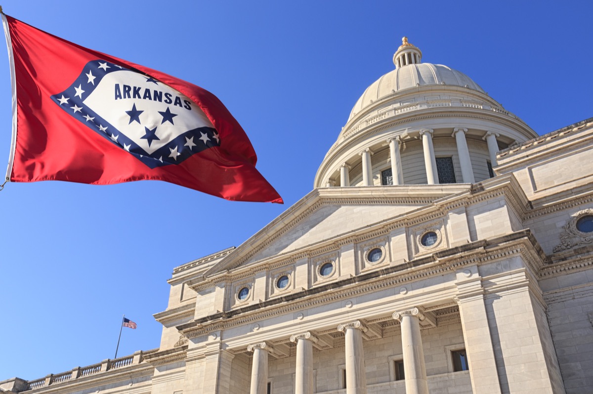 Arkansas flag flying high beside the State Capitol Building