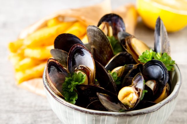 moules frites in a white bowl at restaurant