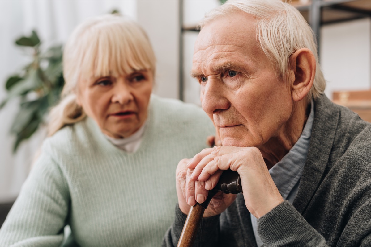 older man with dementia sitting next to wife