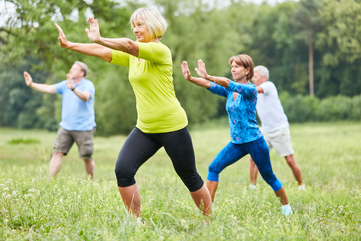 Seniors in the wellness class do Qi Gong or Tai Chi exercise for relaxation